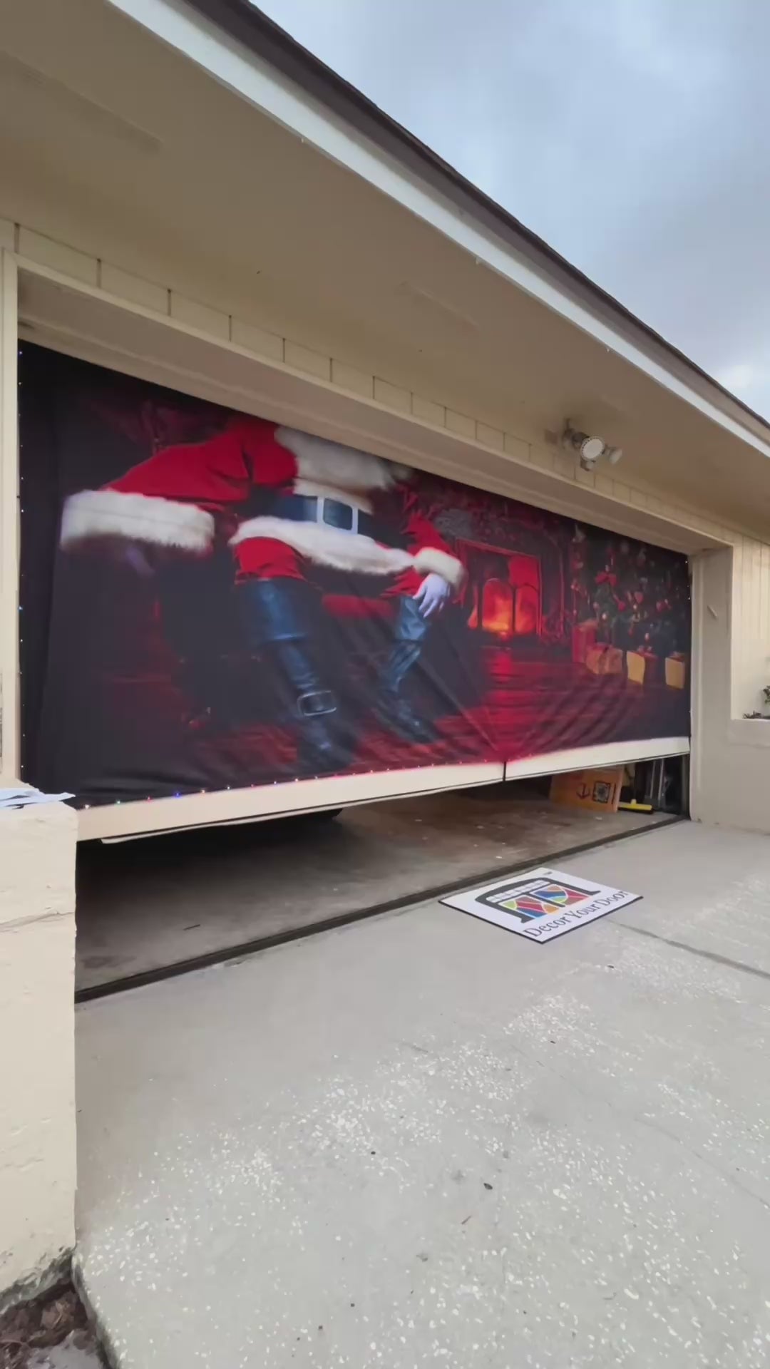 Papá Noel sentado en la sala de estar. Funda para puerta de garaje navideña. Pancarta navideña.
